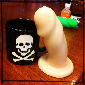 Still life of Randy, coffee mug, Maverick, and lube